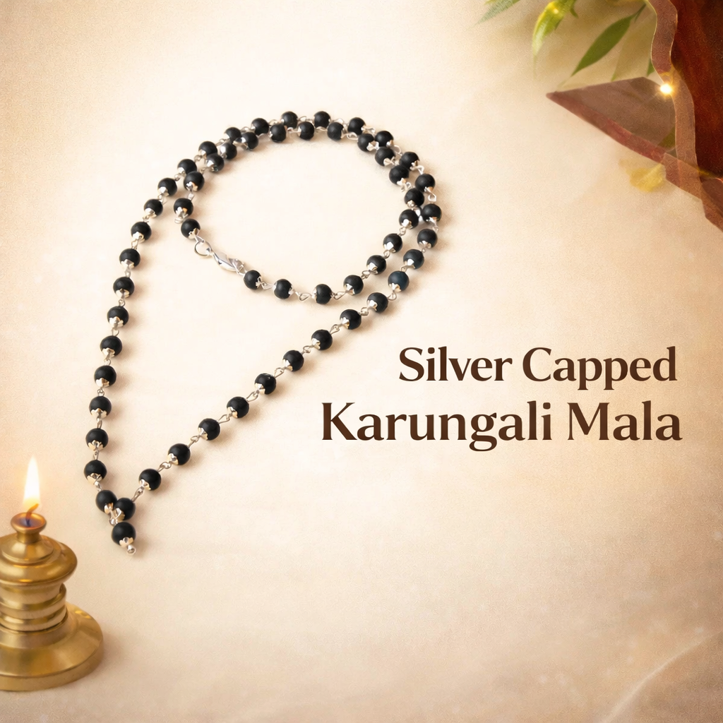 A premium Karungali Mala featuring 108 authentic black ebony wood beads, each meticulously capped with polished pure silver. The dark, matte texture of the wood contrasts beautifully with the gleaming silver caps, finished with a silver-capped Guru bead and a traditional black tassel.