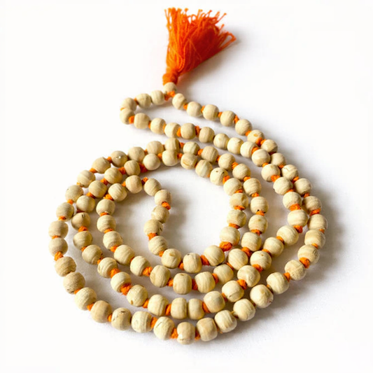 A handcrafted natural Tulsi Mala made from authentic light-brown basil wood beads, strung together with a traditional orange tassel. The beads show natural wood grain textures, symbolizing purity and devotion.