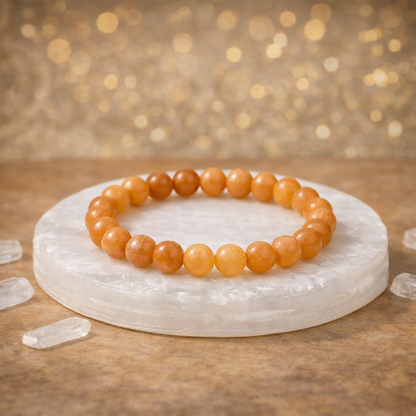 Natural yellow Citrine beaded bracelet resting on a raw white Selenite charging plate for wealth and energy cleansing.