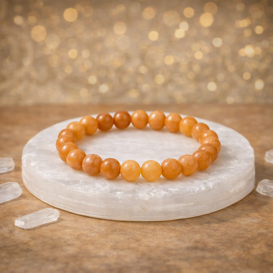 Natural yellow Citrine beaded bracelet resting on a raw white Selenite charging plate for wealth and energy cleansing.