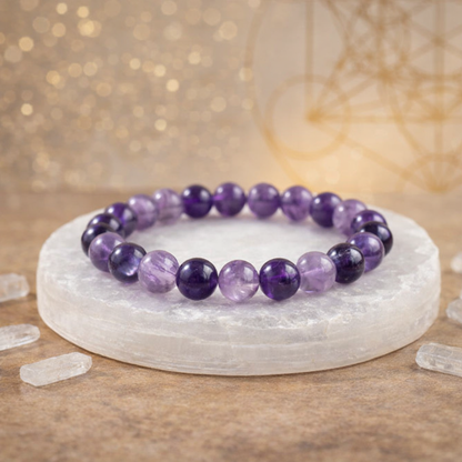 Natural purple Amethyst beaded bracelet resting on a raw white Selenite charging plate for energy cleansing.