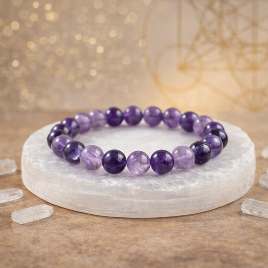 Natural purple Amethyst beaded bracelet resting on a raw white Selenite charging plate for energy cleansing.
