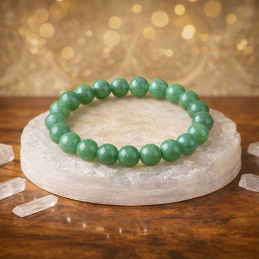 Natural Green Jade beaded bracelet resting on a raw white Selenite charging plate for energy cleansing and abundance.